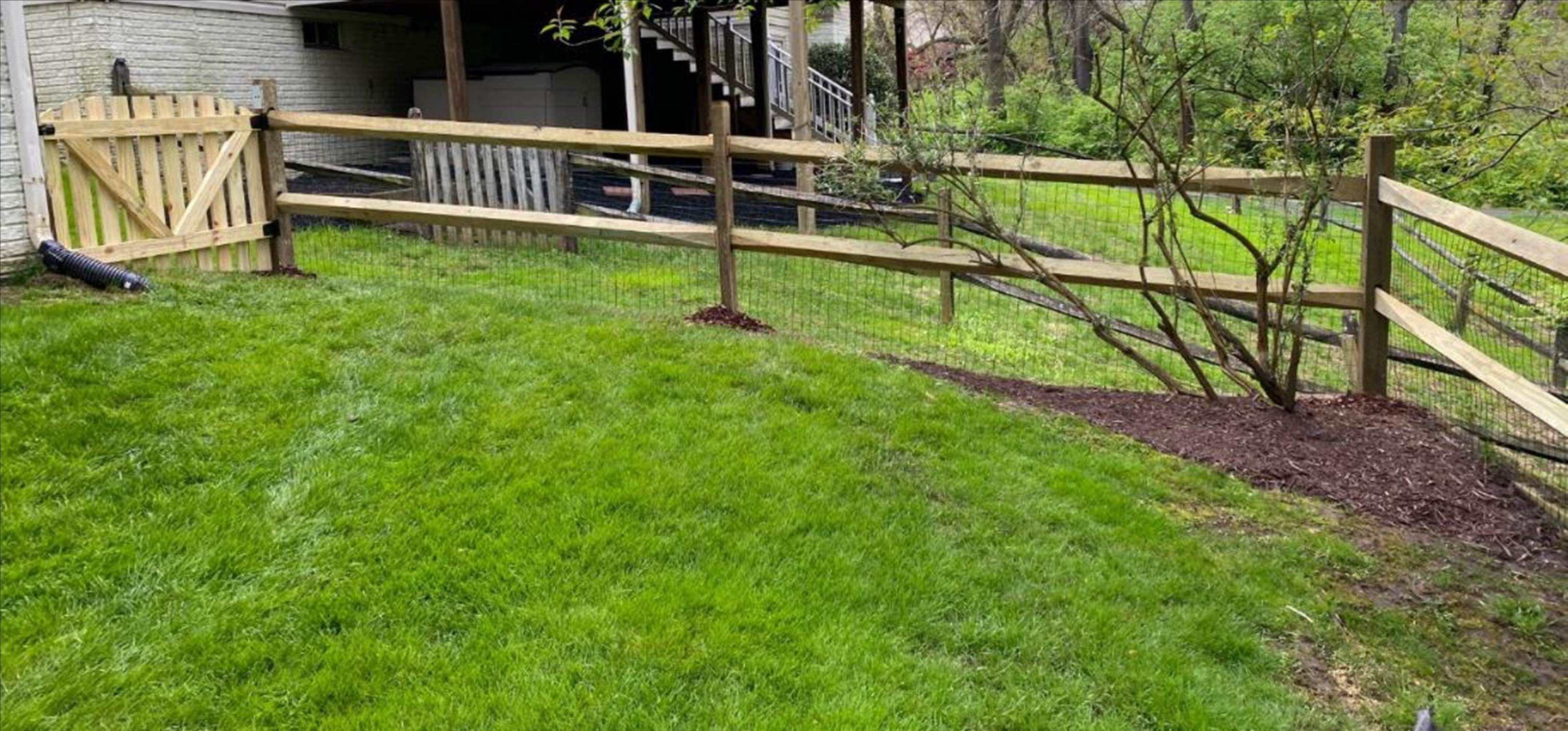 A fenced in yard with a house in the background

Description automatically generated with low confidence